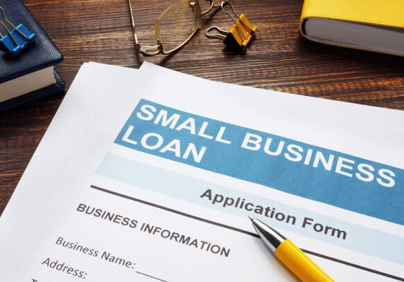 Small business loan application on the wooden surface and documents.